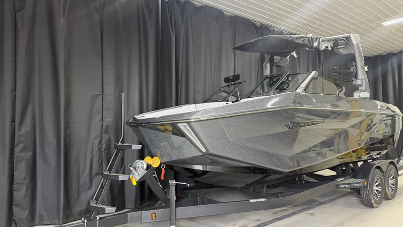 Slide: The Image of A modern boat on a trailer in a warehouse, surrounded by black curtains. - 2
