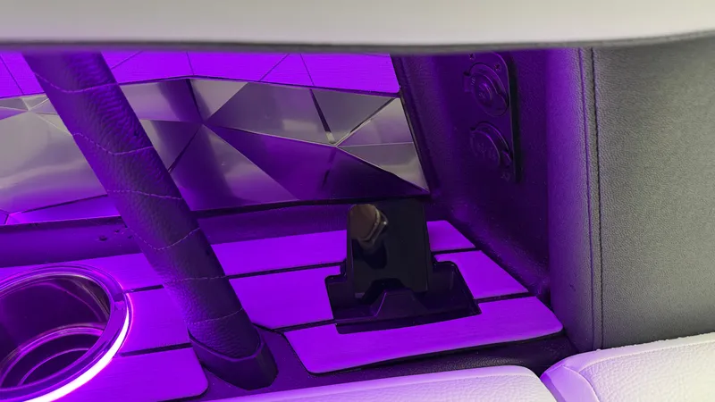 Slide: The Image of Close-up of a boat interior with purple lighting and a cup holder. - 44