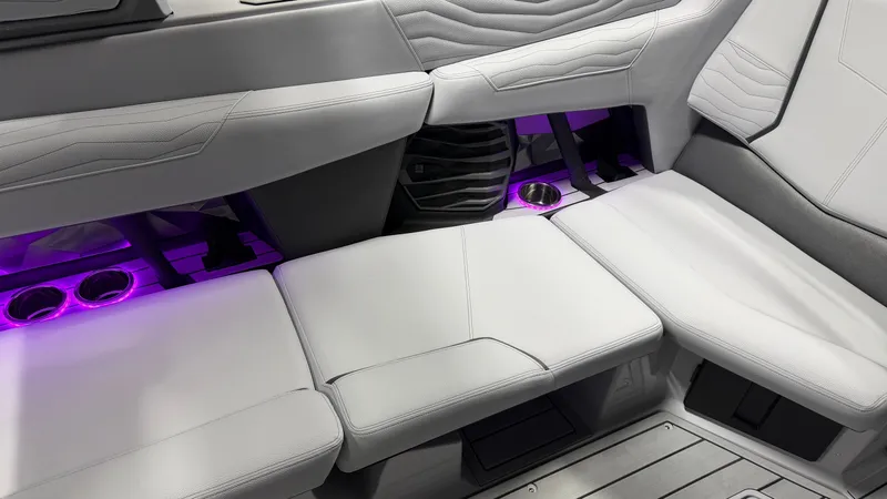 Slide: The Image of White leather seats with purple lighting and cup holders on a boat. - 46