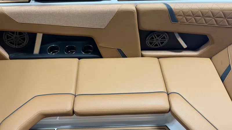 Slide: The Image of The interior of the 2026 Nautique Super Air Nautique GS20 features brown upholstery and speakers. - 39