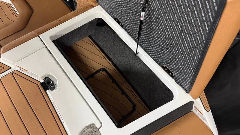 Slide: The Image of An open storage compartment on a Nautique Super Air Nautique GS20 boat with brown upholstery. - 15