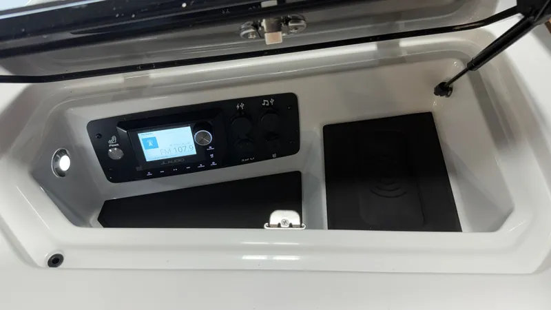 Slide: The Image of The image shows a control panel in a boat with a JL Audio system and storage compartments. - 47