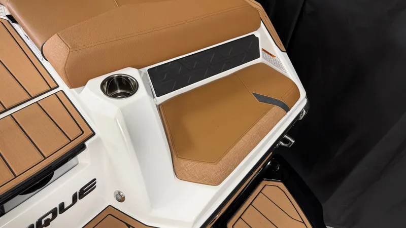 Slide: The Image of The image shows the stern of a 2026 Nautique Super Air Nautique GS20 with brown upholstery and a cup holder. - 13
