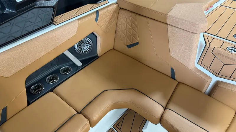 Slide: The Image of Luxurious brown upholstery in the interior of a Nautique Super Air Nautique GS20 boat, featuring a speaker and cup holders. - 31