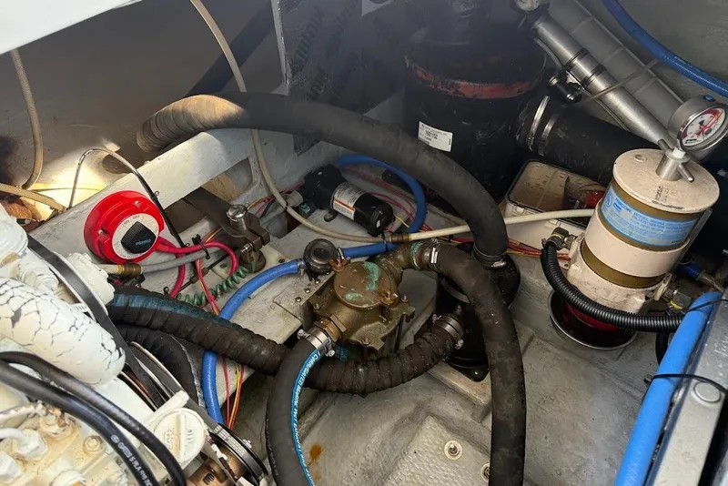 Slide: The Image of Engine compartment of a 1998 Mainship 40 Sedan Bridge with hoses and mechanical components. - 30