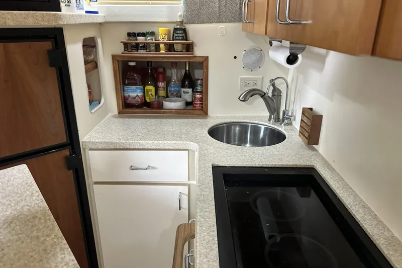 Slide: The Image of 1998 Mainship 40 Sedan Bridge kitchen with sink, stove, and storage shelves. - 5