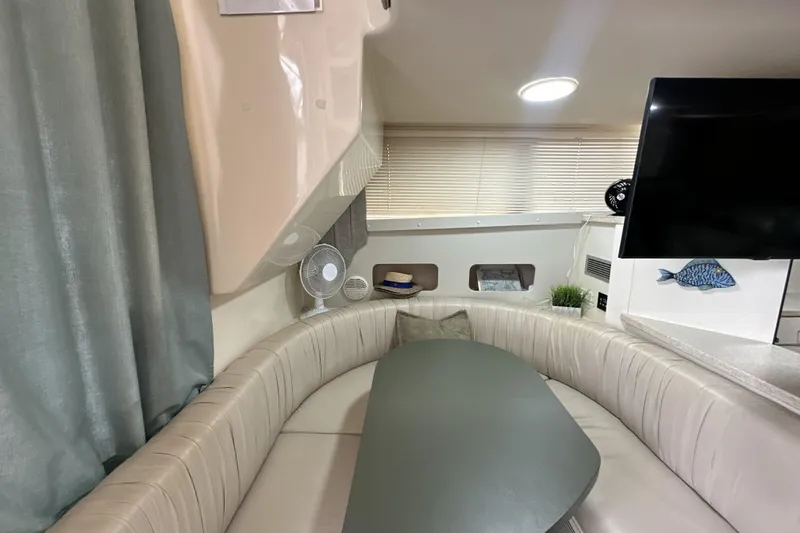 Slide: The Image of 1998 Mainship 40 Sedan Bridge interior with curved seating, table, and decor. - 6