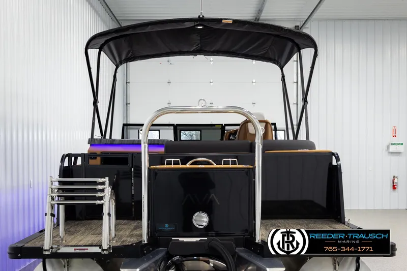 Slide: The Image of 2026 Avalon LSZ ELW pontoon boat in showroom, rear view with canopy and ladder. - 7