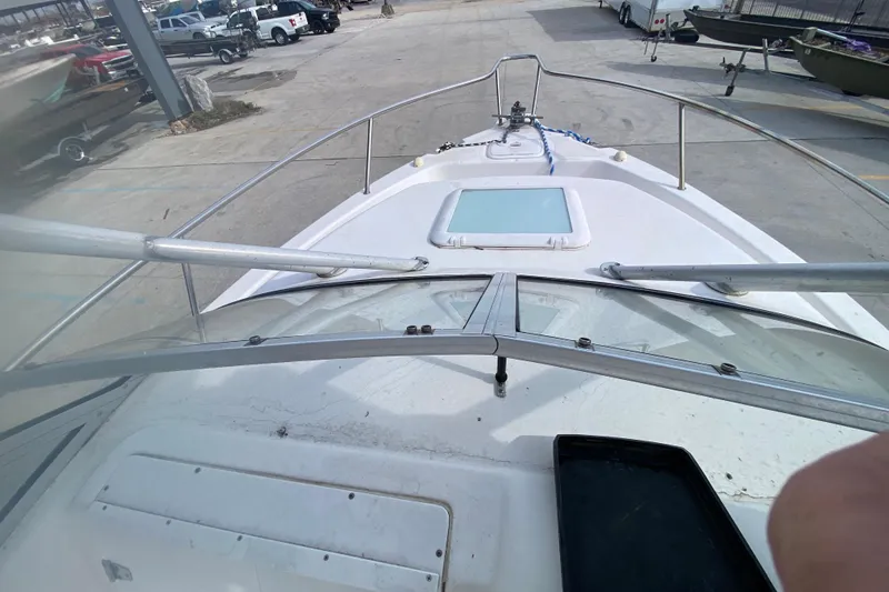Slide: The Image of 2005 PROLINE 21 boat deck view at a marina with surrounding vehicles. - 19