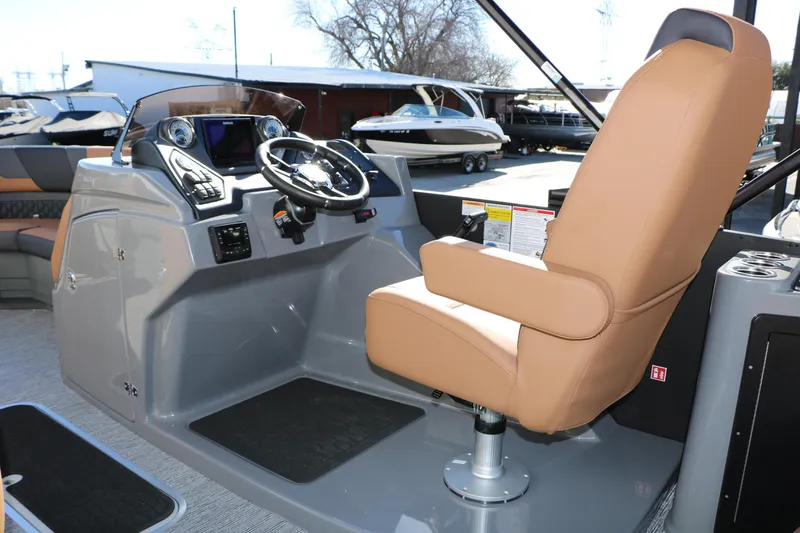 Slide: The Image of 2026 Sylvan L3 DLZ Bar Tri-Toon boat helm with tan captain's chair and modern controls. - 31