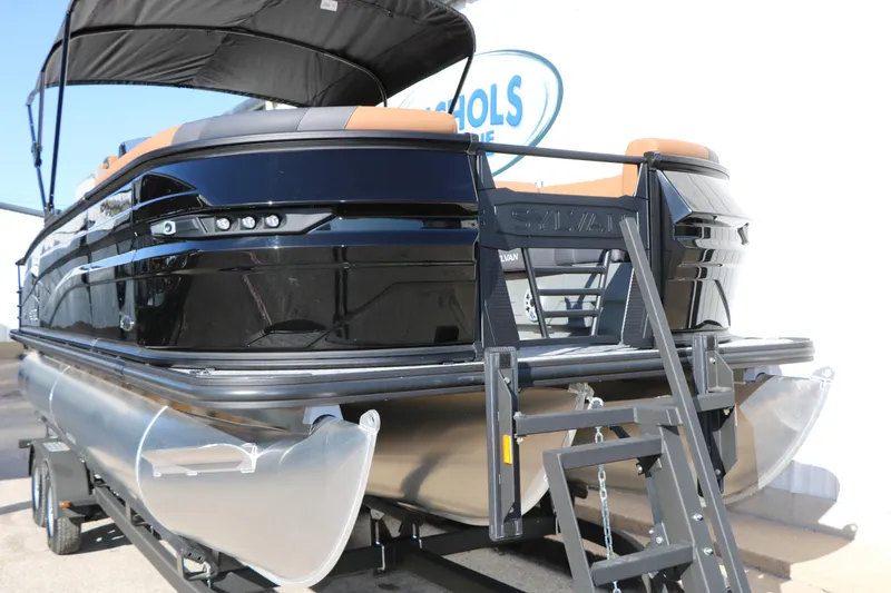 Slide: The Image of 2026 Sylvan L3 DLZ Bar Tri-Toon pontoon boat with sleek black design and ladder. - 5