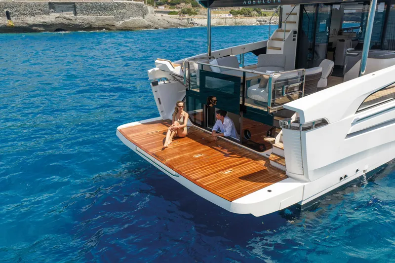 Slide: The Image of Luxury Absolute Navetta 66 yacht, 2027 model, with people relaxing on the deck in clear blue waters. - 7