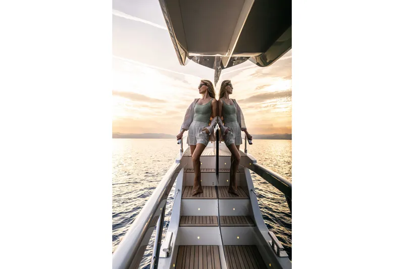 Slide: The Image of Woman enjoying sunset on Absolute Navetta 66 yacht, 2027 model, reflecting on water. - 25