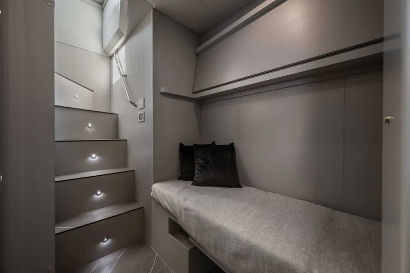 Slide: The Image of Interior of 2027 Absolute Navetta 66 yacht with modern staircase and cozy sleeping area. - 62