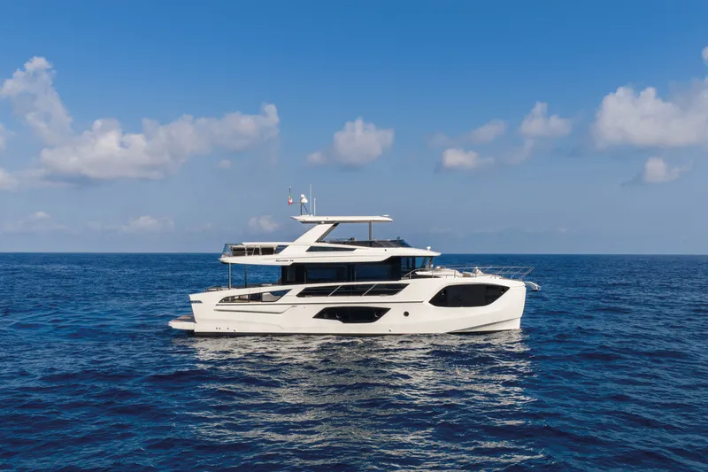 Slide: The Image of Luxurious 2027 Absolute Navetta 66 yacht cruising on open sea under clear blue sky. - 10