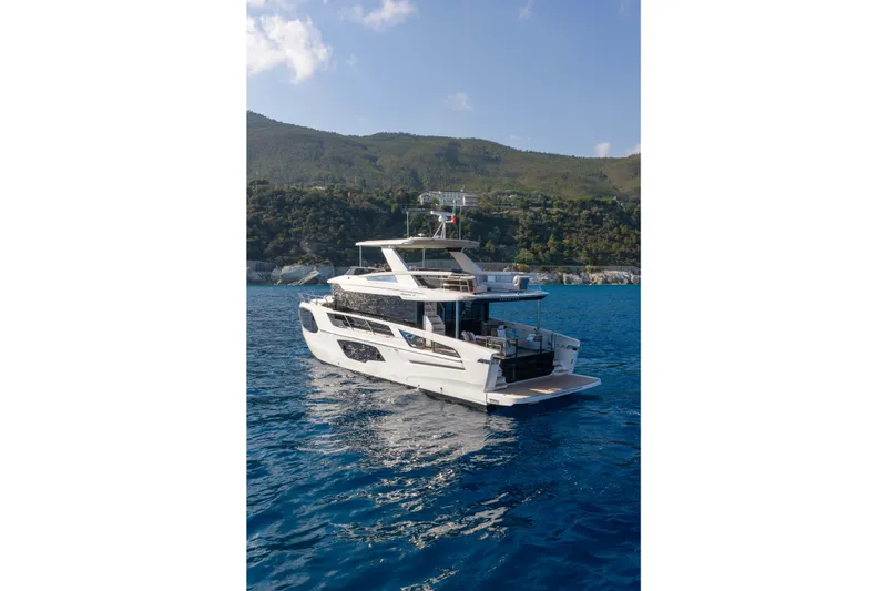 Slide: The Image of Luxury yacht Absolute Navetta 66, 2027 model, cruising in scenic coastal waters. - 9