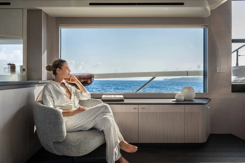 Slide: The Image of Woman relaxing in luxurious Absolute Navetta 66 yacht interior, enjoying ocean view, 2027 model. - 45