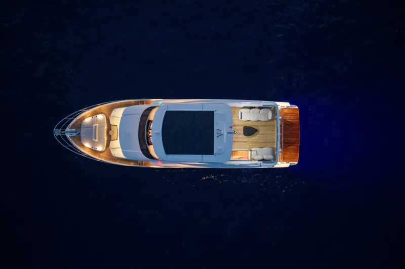 Slide: The Image of Aerial view of 2027 Absolute Navetta 66 yacht illuminated at night on dark water. - 17