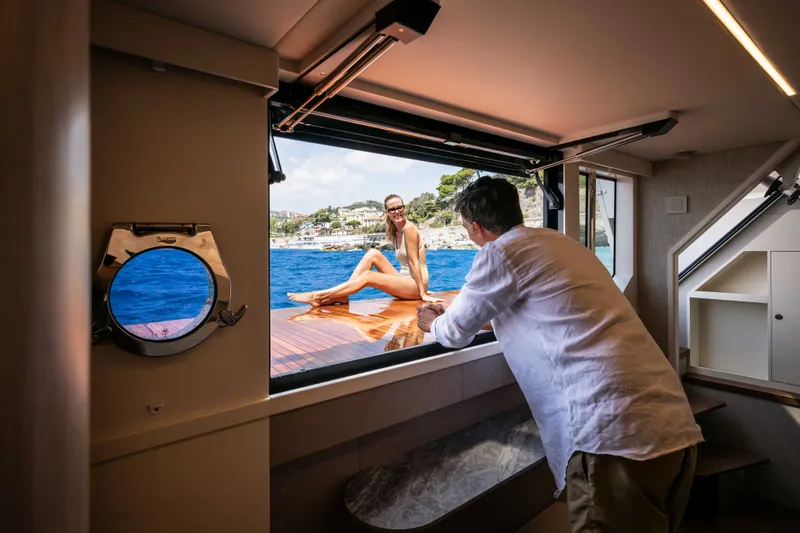 Slide: The Image of Man enjoying view from Absolute Navetta 66 yacht, 2027 model, with scenic ocean backdrop. - 19