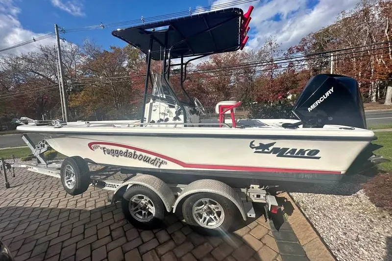The Image of 2006 Mako 224 Center Console boat on trailer with Mercury engine, parked outdoors. - 1
