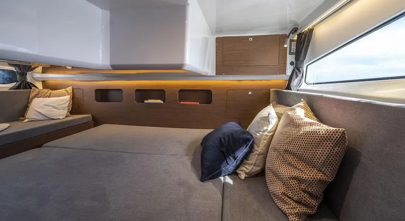 Slide: The Image of Interior of 2026 Beneteau Antares 11, featuring cozy seating and decorative pillows. - 11