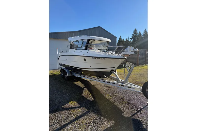 The Image of 2023 Parker Poland 660 Weekend boat on trailer, parked outdoors under clear blue sky. - 0