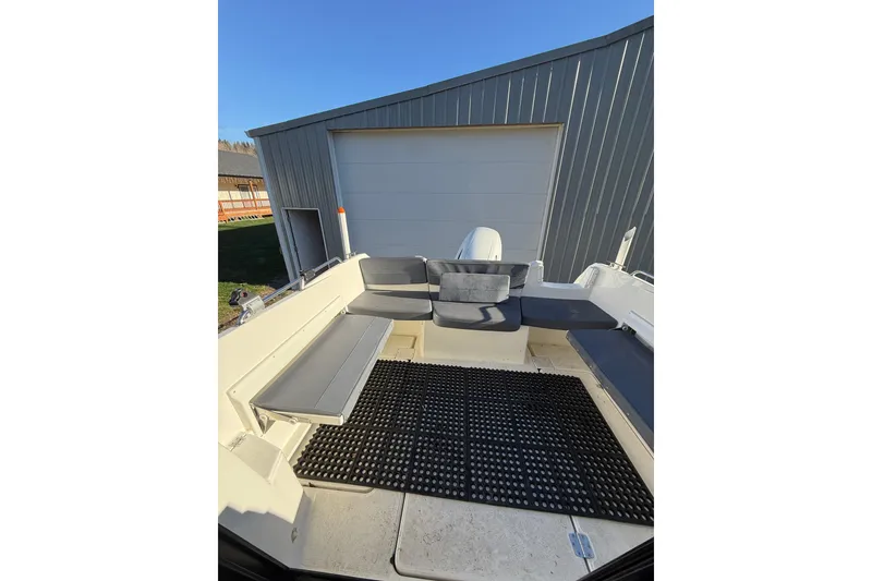 Slide: The Image of 2023 Parker Poland 660 Weekend boat interior with cushioned seating and outdoor storage. - 11