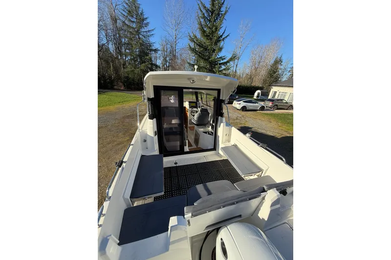 Slide: The Image of 2023 Parker Poland 660 Weekend boat with spacious deck and cabin, surrounded by trees. - 12