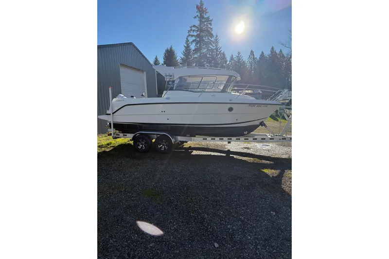 Slide: The Image of 2023 Parker Poland 660 Weekend boat on trailer, parked outdoors under sunlight. - 17