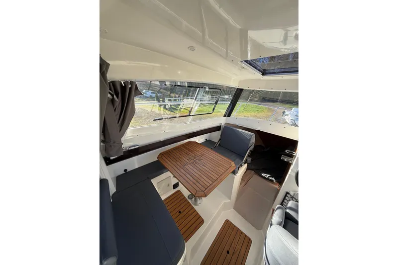 Slide: The Image of Interior of 2023 Parker Poland 660 Weekend boat with wooden table and seating. - 2