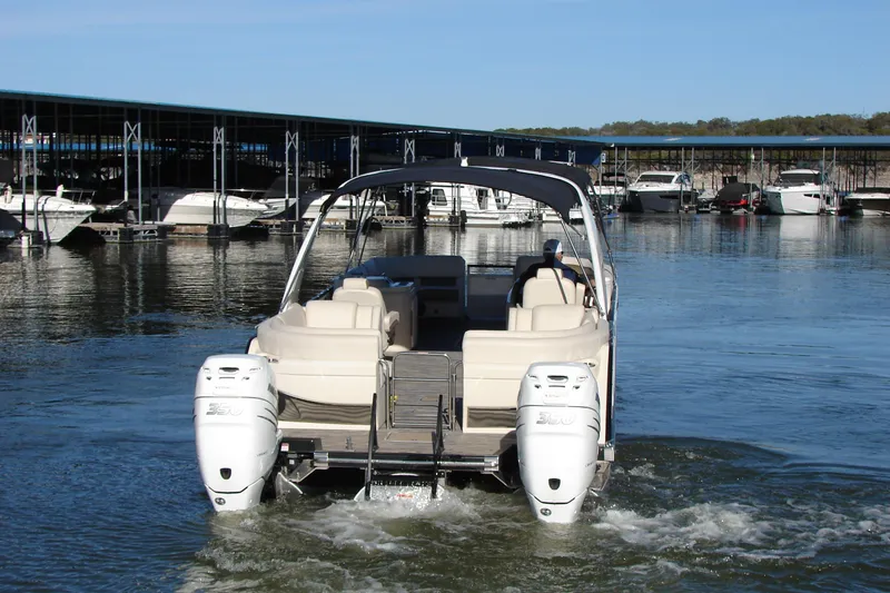 Slide: The Image of 2021 Bennington QX 30 pontoon boat with dual engines in a marina setting. - 5
