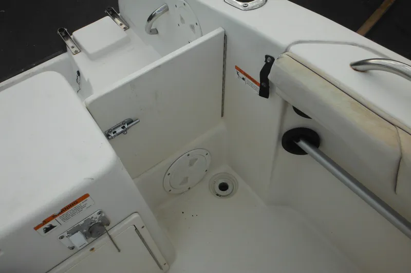 Slide: The Image of 2006 Seaswirl Striper 2301 Dual Console O/B interior, featuring seating and storage compartments. - 24