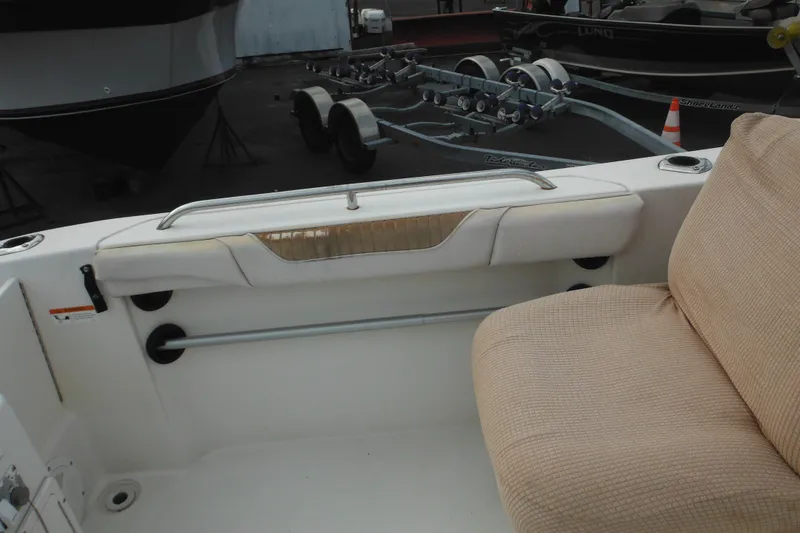 Slide: The Image of 2006 Seaswirl Striper 2301 Dual Console O/B interior with beige seating and boat trailer. - 49