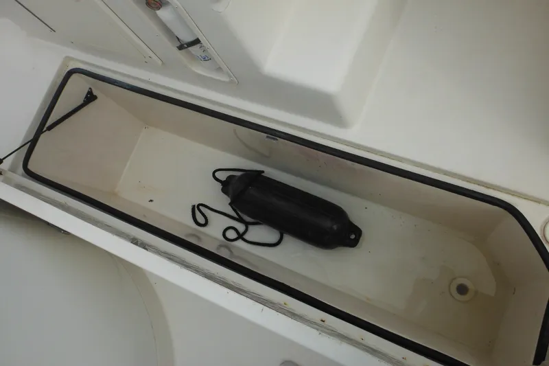 Slide: The Image of Storage compartment in 2006 Seaswirl Striper 2301 Dual Console O/B boat with black fender. - 53