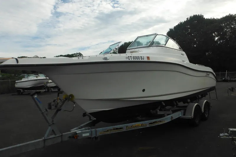 Slide: The Image of 2006 Seaswirl Striper 2301 Dual Console O/B on trailer, parked outdoors. - 6
