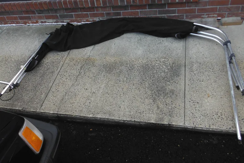 Slide: The Image of Folded bimini top frame on pavement, compatible with 2006 Seaswirl Striper 2301 Dual Console O/B. - 65