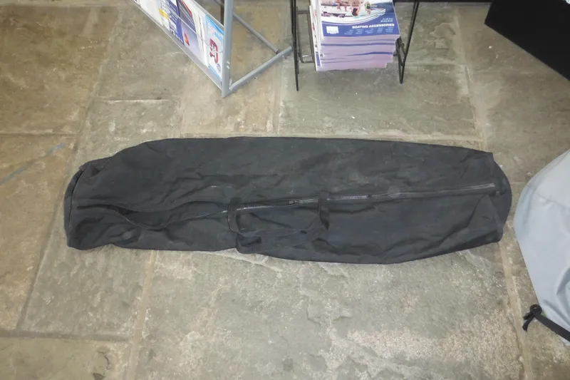 Slide: The Image of Black zippered bag on stone floor near boating accessories display. - 70