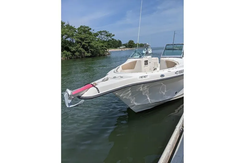 Slide: The Image of 2006 Seaswirl Striper 2301 Dual Console O/B boat docked on calm water. - 77