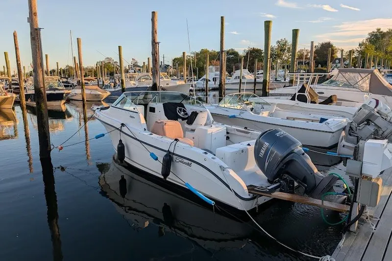 Slide: The Image of 2006 Seaswirl Striper 2301 Dual Console O/B docked at marina, calm water. - 78