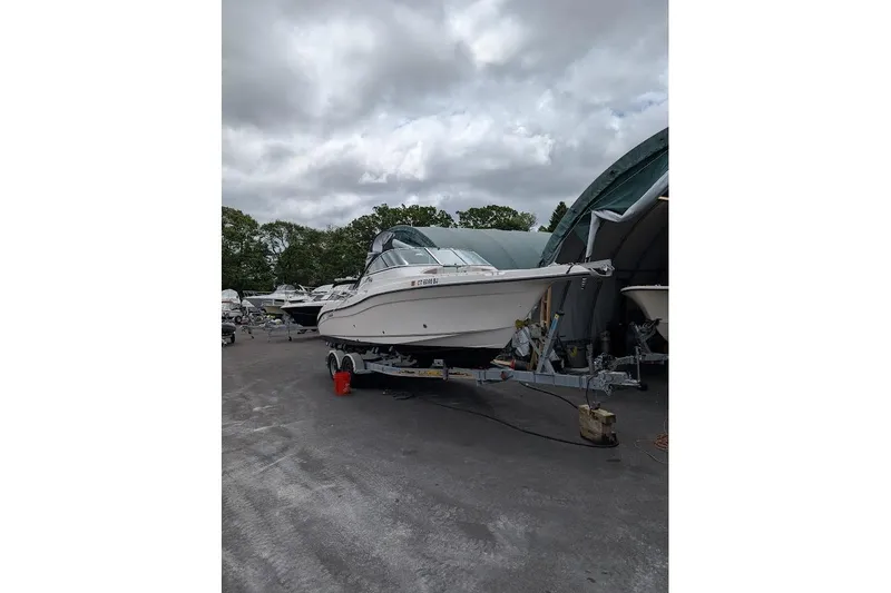 Slide: The Image of 2006 Seaswirl Striper 2301 Dual Console O/B on trailer, parked outdoors. - 79