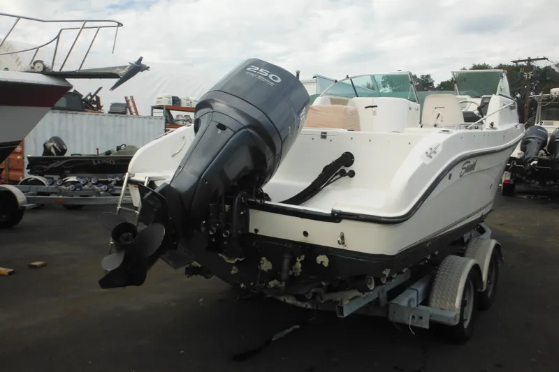 Slide: The Image of 2006 Seaswirl Striper 2301 Dual Console O/B on trailer, featuring powerful outboard motor. - 8