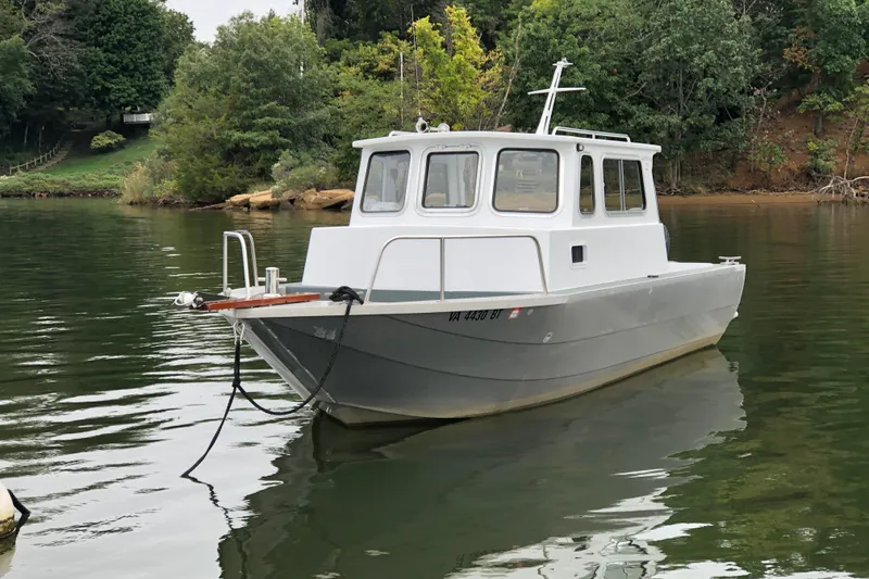 The Image of 2002 Scorpion Lynx boat on calm water, surrounded by lush greenery. - 0