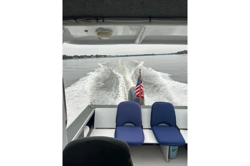 Slide: The Image of 2002 Scorpion Lynx boat cruising on a lake with American flag and wake trail. - 13