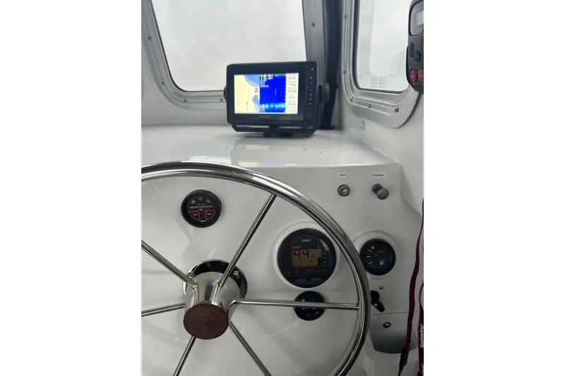 Slide: The Image of Steering wheel and dashboard of 2002 Scorpion Lynx boat with navigation display. - 14