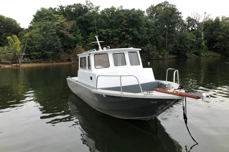 Slide: The Image of 2002 Scorpion Lynx boat on calm water, surrounded by lush green trees. - 2