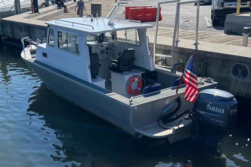 Slide: The Image of Small Scorpion Lynx 2002 boat docked, featuring Yamaha 115 engine and American flag. - 3