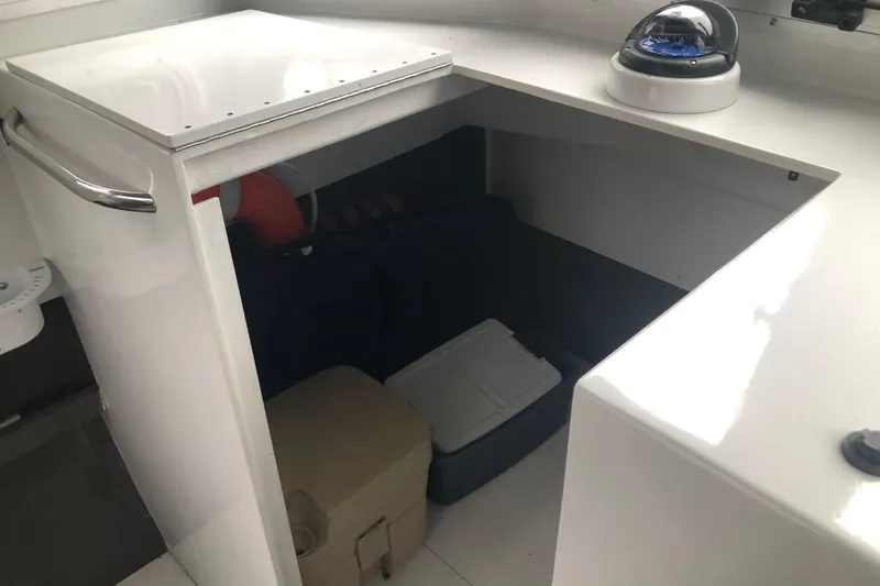 Slide: The Image of Storage compartment in a 2002 Scorpion Lynx boat with a compass and cooler. - 9