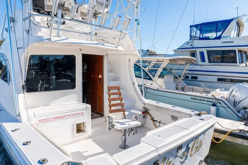 Slide: The Image of 2004 Luhrs 36 Convertible yacht docked, featuring spacious deck and fishing chair. - 10