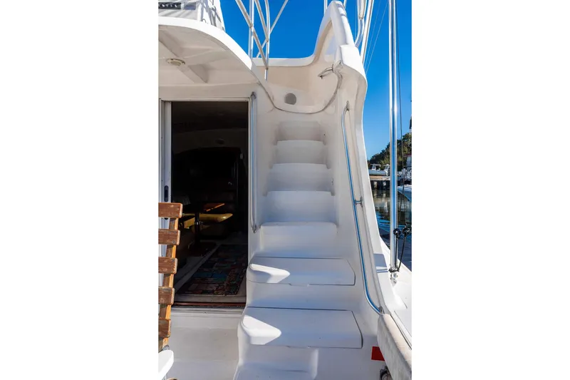 Slide: The Image of 2004 Luhrs 36 Convertible yacht with white stairs and open cabin view. - 13