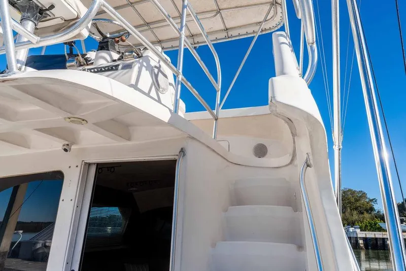 Slide: The Image of 2004 Luhrs 36 Convertible yacht with stairs and railing under clear blue sky. - 16